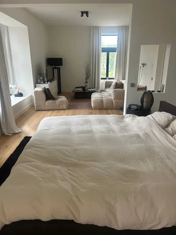 Ruime kamer met groot bed en zithoek bij het raam