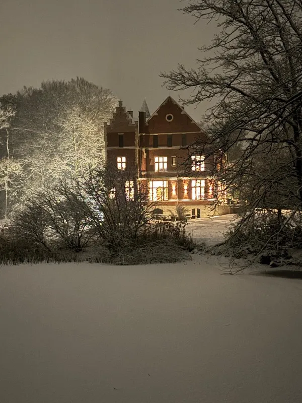 Het verlichte kasteel op een besneeuwde winteravond